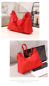 Detail of red quilted PU leather tote bag with chevron texture and front pocket