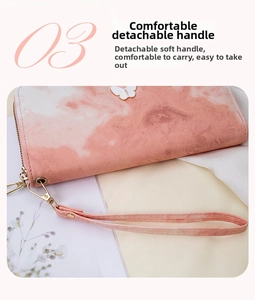Macro detail of pink marble long wallet featuring metal butterfly and detachable wrist strap