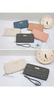 Detail of chevron texture long wallet with gold hardware plaque and wrist strap
