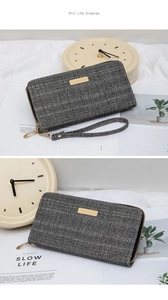 Detail of herringbone fabric wallet with gold metal plate and zipper wrist strap