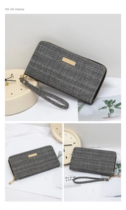 Detail view of grey herringbone pattern long wallet with gold logo plate and wrist strap