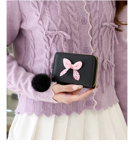 Detailansicht Mini-Geldbörse in Schwarz mit rosa gepunkteter Schleife und weichem Pompon