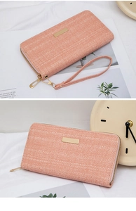 Macro view of peach fabric long wallet featuring herringbone texture and golden zipper detail