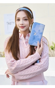 Close-up of long zip wallet in light blue marble print with butterfly charm and wrist strap
