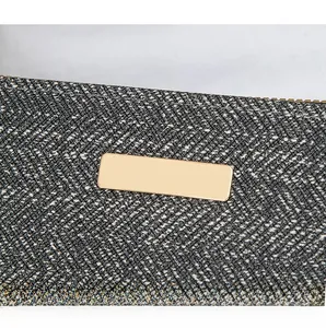Detail of grey cross-pattern fabric with gold metal hardware and zipper on long wallet