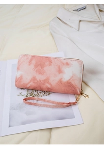 Detail of pink marble textured leather clutch bag with golden zipper and wristlet strap