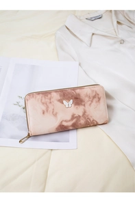 Detail of a pink marble zip wallet for women featuring a stylish butterfly emblem and gold zip