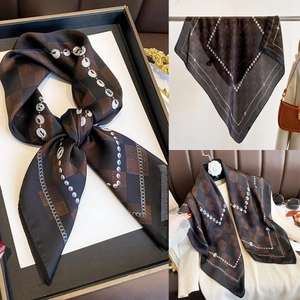 Detailed view of the brown checkerboard silk scarf with chain print and satin finish