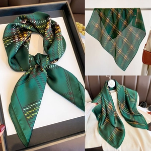 Detail of green plaid silk scarf showing texture and multiple styling options