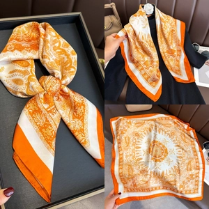 Detail of square silk scarf with orange paisley print and bohemian mandala patterns