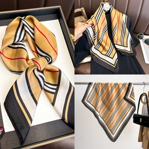 Close-up of silk square scarf showing classic stripe patterns and smooth satin texture
