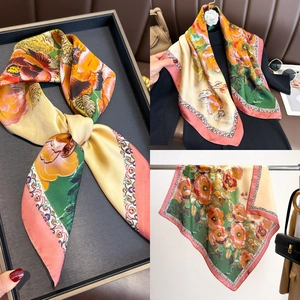 Detail of vintage floral silk scarf with warm yellow and green tones on a black sweater
