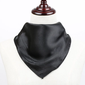 Détail d'un élégant foulard en satin noir noué sur mannequin au fini soyeux