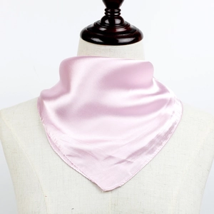 Carré en satin rose plié et exposé sur un buste de mannequin en tissu blanc