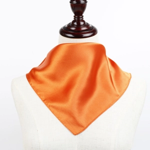 Détail du foulard en satin orange vif sur mannequin montrant la texture soyeuse