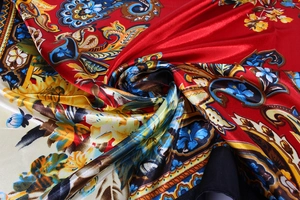 Macro detail of red paisley satin scarf with silky texture and intricate floral pattern