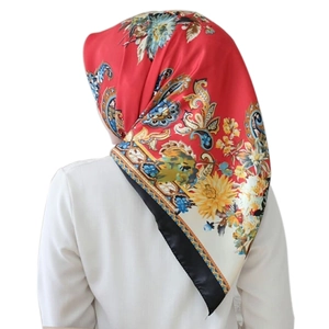 Detail of red satin square scarf with paisley floral print and black border finish