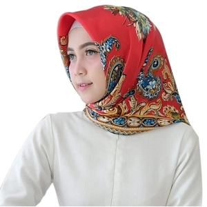 Close-up of red paisley satin square hijab scarf worn by a model in a studio shot