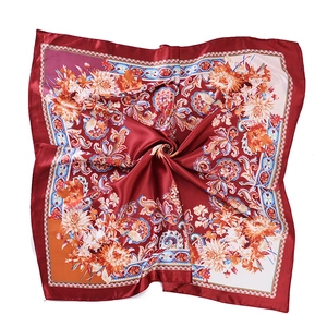 Close-up of red bohemian satin square scarf with intricate orange chrysanthemum floral prints
