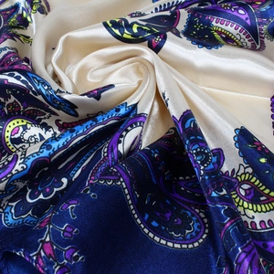Détail d'un foulard en satin cachemire violet montrant la texture de soie et motifs