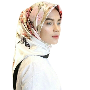 Dettaglio di un elegante foulard di raso con stampe di rose e farfalle