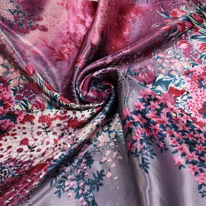 Close-up of floral print satin scarf fabric with vibrant pink and blue flower patterns
