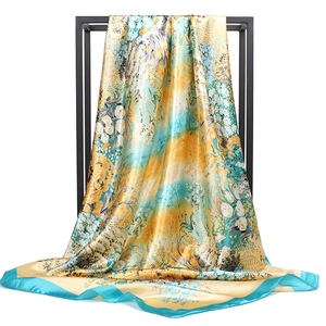 Detail of printed satin square scarf draped on black frame with floral patterns