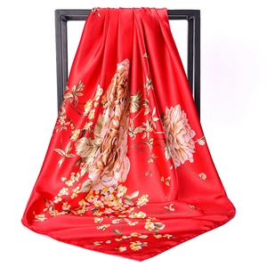 Detail of red satin scarf with vintage floral print hanging on a black metal frame