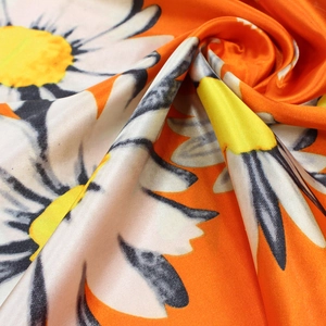 Orange silk satin scarf featuring large white daisy print and a glossy finish