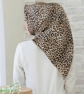 Nahaufnahme des Satin-Quadrat-Schals mit Leopardenmuster und seidiger Textur am Modell
