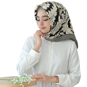 Dettaglio di hijab in raso stampato con eleganti motivi di foglie nere e beige