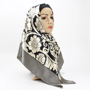 Dettaglio dell'hijab in raso con stampa floreale bianca e nera e bordo a pois eleganti
