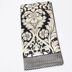 Dettaglio di un foulard in raso con motivi floreali damascati e bordo a pois chic