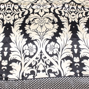 Dettaglio di un foulard in raso con motivi damascati e bordo a pois in bianco e nero
