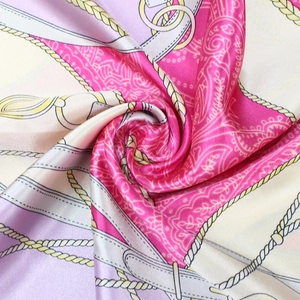 Détail d'un foulard carré en satin avec motifs de chaînes paisley et fini brillant