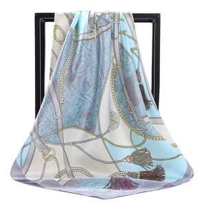 Détail d'un foulard carré en satin avec motifs nautiques et imprimés paisley sur un cadre