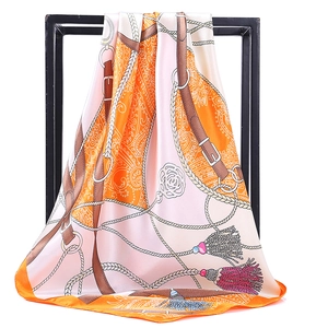 Détail d'un foulard carré en satin de soie avec motifs équestres et bords roulés