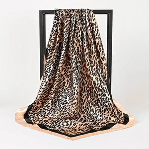Leopard print silk square scarf with contrast border on black minimalist display frame