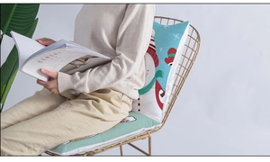 Detail of Christmas snowman cushion showing soft texture on a modern golden chair