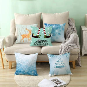 Set of five Christmas themed pillow covers with snowflake and reindeer prints on a sofa