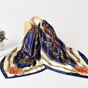 Detailed texture of satin square scarf draped on a straw bag with equestrian patterns