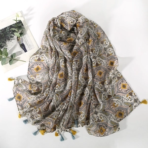 Detail of paisley print scarf in beige with colorful floral patterns and tassels