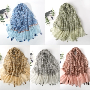 Flat lay of colorful cotton linen scarves with geometric prints and fringe details