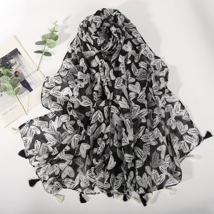 Elegant black and white heart print scarf with tassels shown at a 45-degree angle