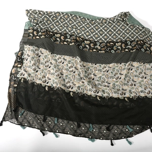 Detail of paisley and geometric pattern patchwork scarf with decorative corner tassels