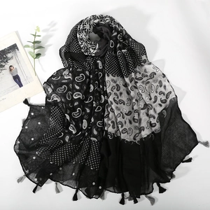 Close-up of paisley and polka dot print scarf with decorative tassel fringe edges