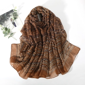 Detail of soft breathable voile scarf featuring brown bohemian geometric patterns