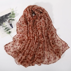 Détail d'une écharpe à motif de feuilles marron avec une texture de tissu léger et fin