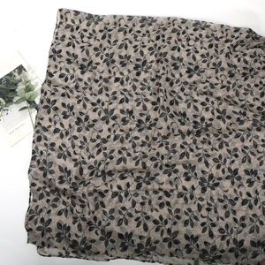 Détail de l'écharpe à imprimé feuilles montrant la texture légère et le motif naturel