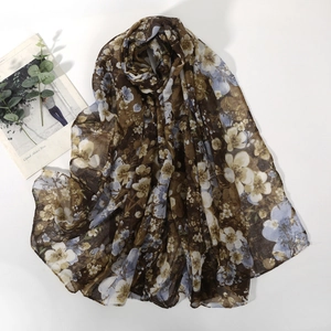 Detail of floral printed voile scarf with fine stitching on a soft brown fabric